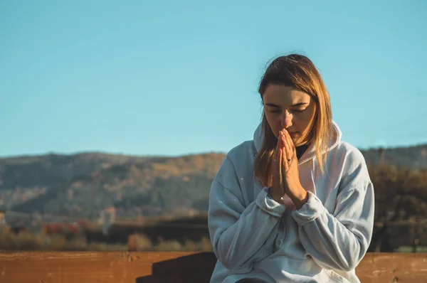 Зранку дівчина закрив очі, молячись на відкритому повітрі рук скласти в молитві концепції для віри, духовність, концепцію релігії. — стокове фото