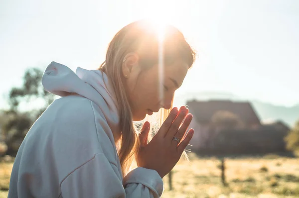 Por la mañana Chica cerró los ojos, orando al aire libre, Las manos dobladas en concepto de oración por la fe, la espiritualidad, el concepto de religión . —  Fotos de Stock