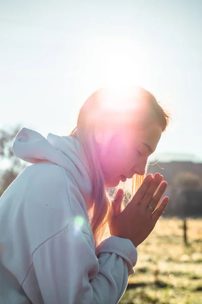Por la mañana Chica cerró los ojos, orando al aire libre, Las manos dobladas en concepto de oración por la fe, la espiritualidad, el concepto de religión . —  Fotos de Stock