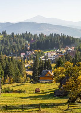 Ağaçlar, sıcak ışık dağlar denk sarı ve kırmızı yaprakları ile kaplı. Karpat, Ukrayna. Sonbahar köy sahne.