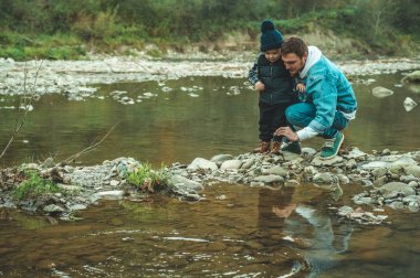Baba ve oğul yürümek ve birlikte oynamak. Dağlarda sonbahar