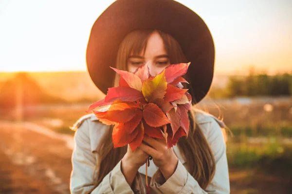 Beauté Romantique Fille En plein air profiter de la nature tenant des feuilles dans les mains. Beau modèle d'automne avec des cheveux rougeoyants. Lumière du soleil — Photo