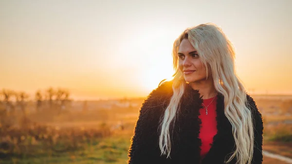 Beleza menina romântica ao ar livre apreciando a natureza. Modelo de outono bonito com cabelo acenando brilho. Luz solar no pôr do sol . — Fotografia de Stock