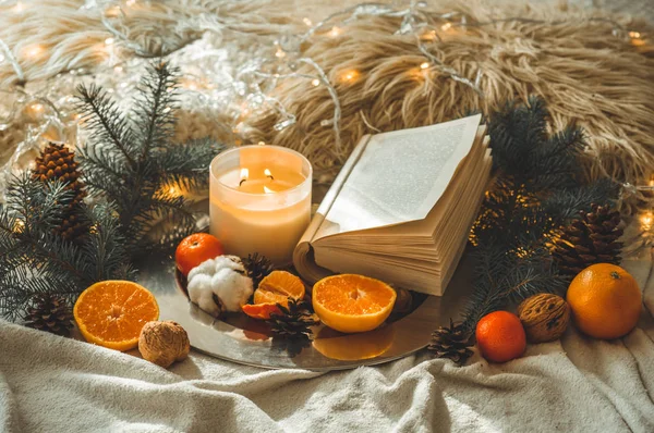 Libro e mandarini in una composizione invernale, alberi di Natale, candele, coni, cotone, cannella. Simbolo di Capodanno e Natale — Foto Stock