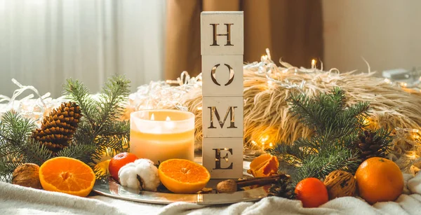 La parola HOME e mandarini in una composizione invernale, alberi di Natale, candele, coni, cotone. Simbolo di Capodanno e Natale — Foto Stock