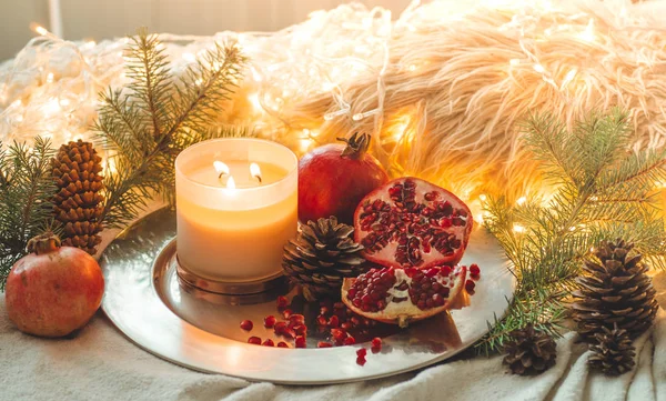 Acogedora mañana de invierno en casa con frutas. Granada en una composición invernal, árboles de Navidad, conos en un frasco en el fondo — Foto de Stock