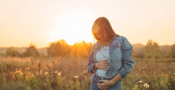 Young Pregnant Woman holding ultrasound photo at Sunset and Embracing her Belly. 4 Month Pregnancy. Maternity Concept. Toned Photo — Stock Photo, Image