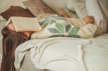 Çünkü üniversite sınavına hazırlanıyor ile kitap okuma yüzünü kaplayan kitap ile yatakta uyuyan güzel genç kadın