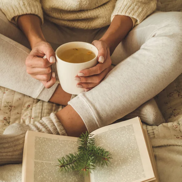 Cozy home. Beautiful girl is reading a book on the bed. Good morning with tea. Pretty young girl relaxing. The concept of reading — Stock Photo, Image