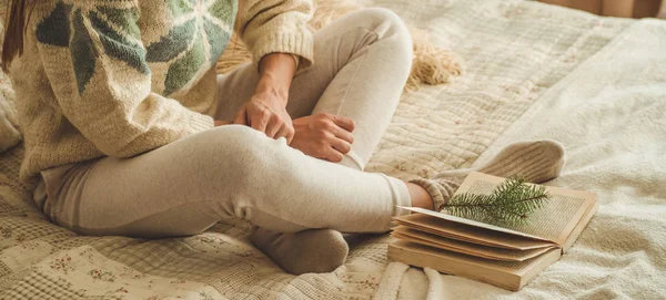 Acogedora casa. Hermosa chica está leyendo un libro en la cama. Buenos días con el té. Una chica joven y bonita relajándose. El concepto de lectura — Foto de Stock