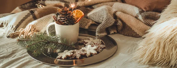 Tazza con coni e arancio secco con sparkler, ramo di abete, biscotti di Natale, accogliente coperta lavorata a maglia, Capodanno, nature morte di Natale . — Foto Stock