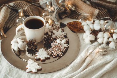 fincan çay veya kahve, köknar dalı, kar taneleri, rahat örgü battaniye, pamuklu ve rahat garland, yeni yıl şeklinde kurabiye
