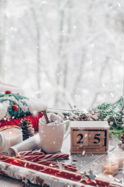 25 Aralık takvim. Noel dekor: sıcak kazak, lokum, şekerleme, mumlar ve Noel ağacı ile sıcak kakao fincan. Kış ruh hali, tatil dekorasyon.
