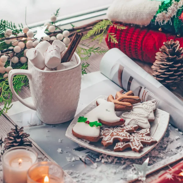 Christmas decor: Warm sweater, cup of hot cocoa with marshmallow, candy, candles and Christmas tree. Winter mood, decoration.