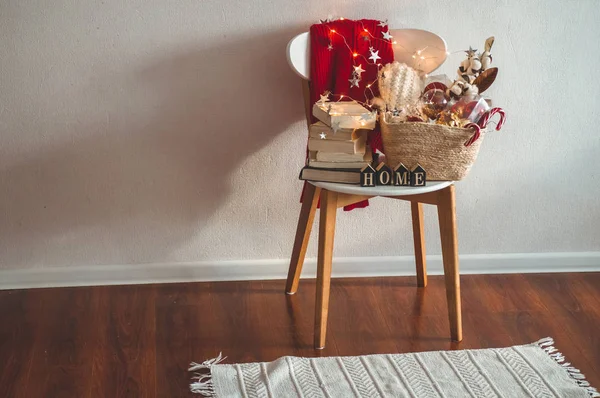 Kış kazak Noel süsleri, kitap bir sepet ile bir sandalyeye koydu. Tatil dekorasyon yazıt ev ile. — Stok fotoğraf