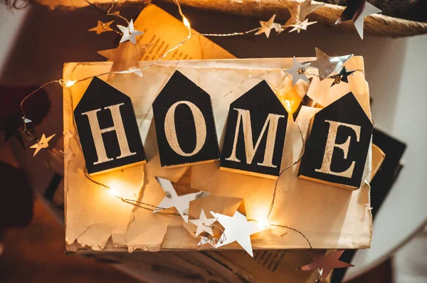 Thuis decoraties in het interieur van een brief met inscriptie huis op een boeken. LED string lichten. De lezing van de winter. Huis, comfort — Stockfoto