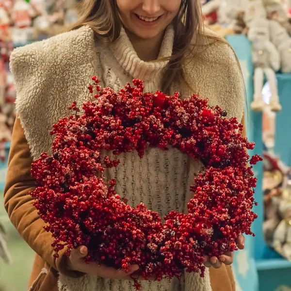 Karangan bunga Natal berkarat memegang buah merah di cabang toko. Citra murung atmosfer di lokakarya liburan — Stok Foto