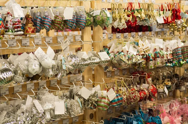 Verkoop van Kerstmis speelgoed in de supermarkt. Ballen van verschillende kleuren voor de kerstboom op de schappen van de supermarkt. — Stockfoto