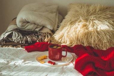 Kırmızı fincan çay Kamkat ve beyaz bir yatakta iki kalp Çerezler ile. Cozy Home. Sevgililer günü kavramı