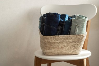 beyaz duvar kazık kavramı yakınındaki ahşap sandalye üzerinde kot denim kumaş konfeksiyon tek renkli gri mavi keten Tekstil yığılmış