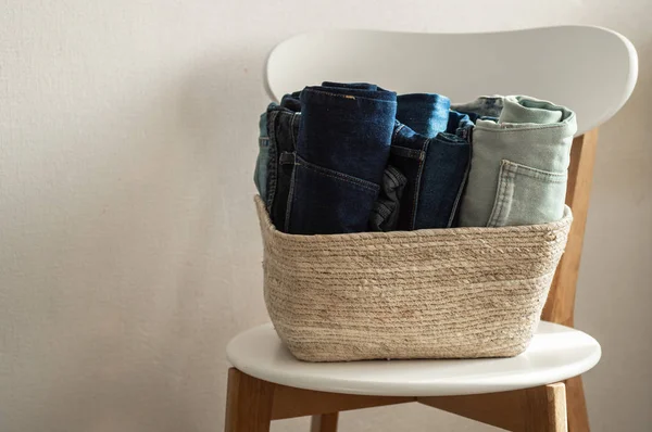 beyaz duvar kazık kavramı yakınındaki ahşap sandalye üzerinde kot denim kumaş konfeksiyon tek renkli gri mavi keten Tekstil yığılmış