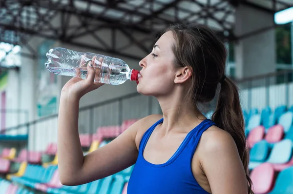 Fitness sport woman in fashion sportswear, the girl is drinking water, fitness exercise in the city street — Stock Photo, Image