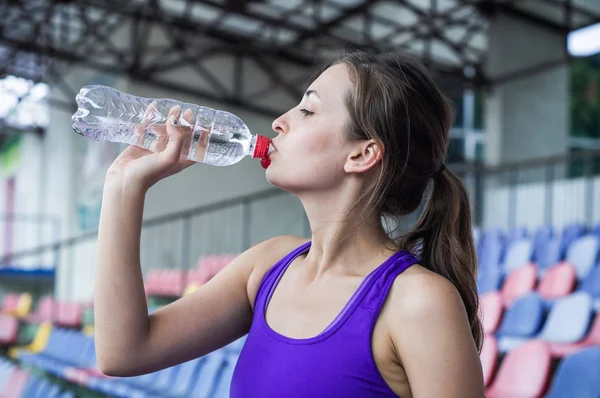 Fitness sport woman in fashion sportswear, the girl is drinking water, fitness exercise in the city street — Stock Photo, Image