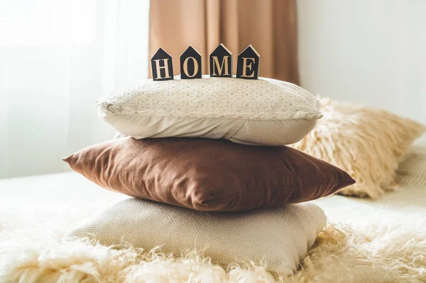 Sporo przytulne Poduszki dekoracyjne i napis Home — Zdjęcie stockowe