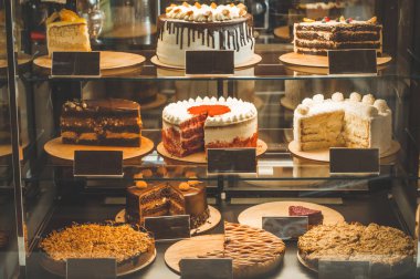 Samimi bir kafe penceresindeki birçok lezzetli kek. Lezzetli tatlılar.