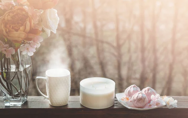 Naturaleza muerta de primavera acogedora: taza de té caliente con ramo de flores de primavera en el alféizar de la ventana vintage con un malvavisco rosa —  Fotos de Stock