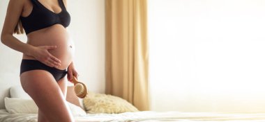 Hamilelik ve kuru masaj. Hamile Kadın bacağının üstüne kuru fırça tutan