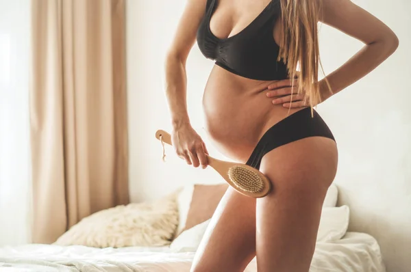 임신 및 건식 마사지. 임신 여자 들고 마른 브러쉬 에 상단 의 그녀의 다리 — 스톡 사진