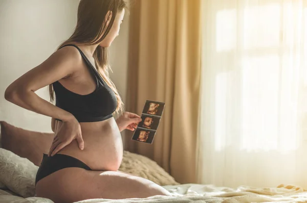 Mulher grávida segurando imagem de ultra-som. Conceito de gravidez, cuidados de saúde, ginecologia, medicina — Fotografia de Stock