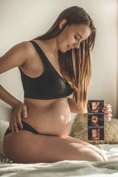 Mujer embarazada sosteniendo imagen de ultrasonido. Concepto de embarazo, cuidado de la salud, ginecología, medicina — Foto de Stock