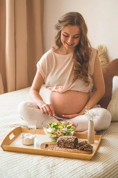 Pregnancy and healthy organic nutrition. Pregnant woman enjoying fresh vegetable salad in bed, free space — Stock Photo, Image