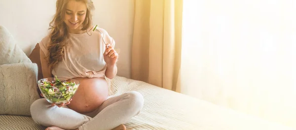 Grossesse et alimentation biologique saine. Femme enceinte dégustant une salade de légumes frais au lit, espace libre — Photo