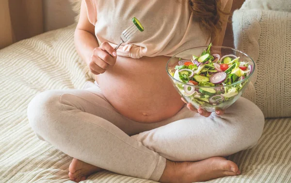 Embarazo y nutrición orgánica saludable. Mujer embarazada disfrutando de ensalada de verduras frescas en la cama, espacio libre — Foto de Stock