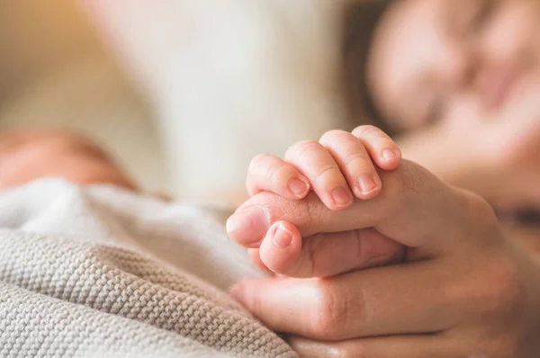 Female hand holding her newborn baby hand. Mom with her child. Maternity, family, birth concept — Stock Photo, Image