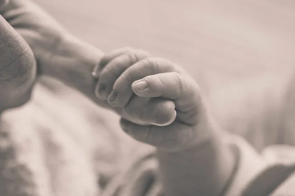 Female hand holding her newborn baby hand. Mom with her child. Maternity, family, birth concept — Stock Photo, Image