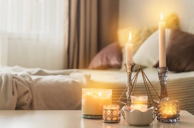 Ev arka planında şamdanlar olan bir sürü mum. Ev ve ev dekorasyonu. Mumlar alev