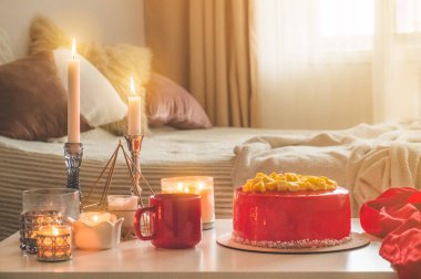 Lezzetli bir pasta ve çay kırmızı bir fincan ile sade bir arka plan üzerinde mumlar bir sürü