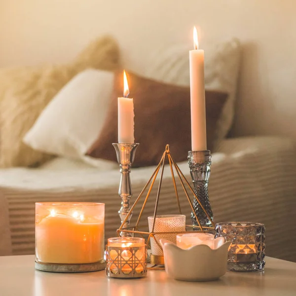 Un montón de velas con candelabros en el fondo del hogar. Decoración del hogar y el hogar. Velas llama — Foto de Stock