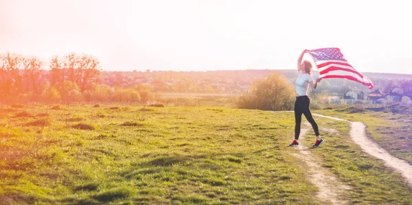 Women running in the field with American flag USA celebrate 4th of July — ストック写真