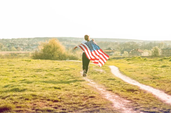 Women running in the field with American flag USA celebrate 4th of July — ストック写真