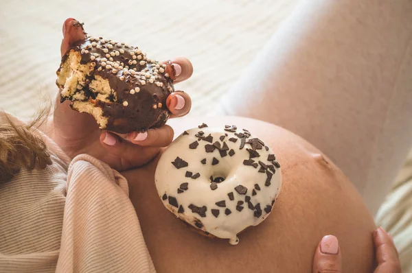 Pregnancy and nutrition. Pregnant woman enjoying donuts and tea in bed, free space. Concept of expectation and health — Stock Photo, Image