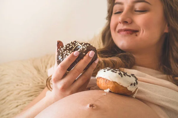 Grossesse et nutrition. Femme enceinte dégustant beignets et thé au lit, espace libre. Concept d'attente et de santé — Photo