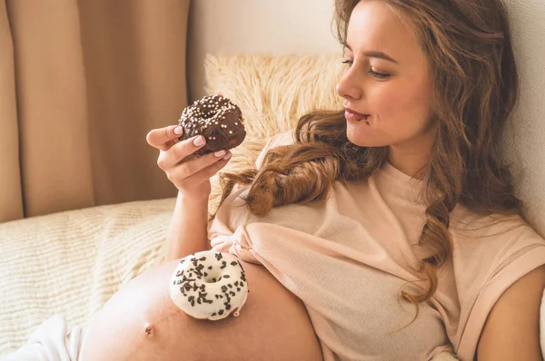 Grossesse et nutrition. Femme enceinte dégustant beignets et thé au lit, espace libre. Concept d'attente et de santé — Photo