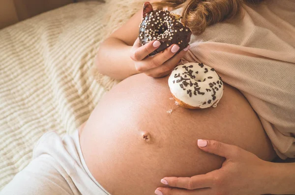 Grossesse et nutrition. Femme enceinte dégustant beignets et thé au lit, espace libre. Concept d'attente et de santé — Photo