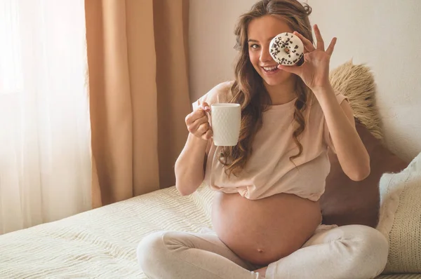 Schwangerschaft und Ernährung. Schwangere genießen Donuts und Tee im Bett, freier Platz. Konzept der Erwartung und Gesundheit — Stockfoto