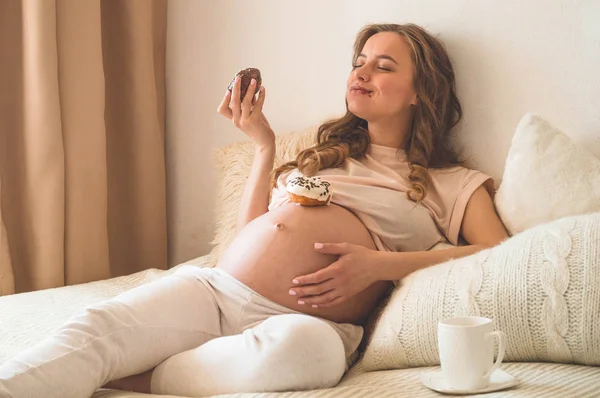 Embarazo y nutrición. Mujer embarazada disfrutando de donas y té en la cama, espacio libre. Concepto de expectativa y salud — Foto de Stock